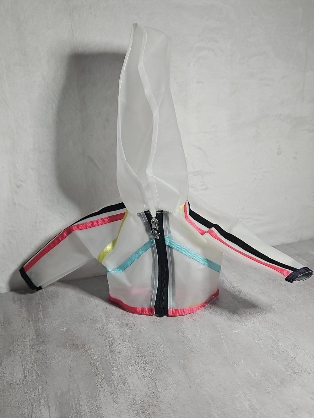 transparent vinyl hooded doll jacket with a black zipper and colorful neon seam